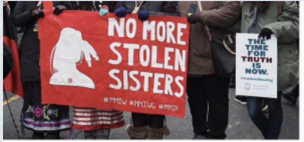 Close up of signs held by demonstrators reading, "No more stolen sisters" and "The time for truth is now".
